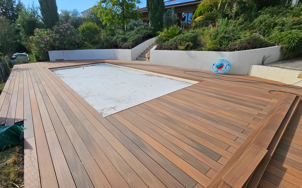 Terrasse extérieure avec piscine en construction, entourée de platelage en bois exotique