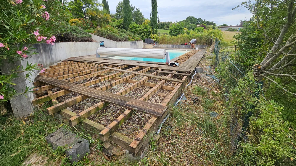 Escalier extérieur en bois avec terrasse, construction sur plusieurs niveaux entre murs crépis beiges