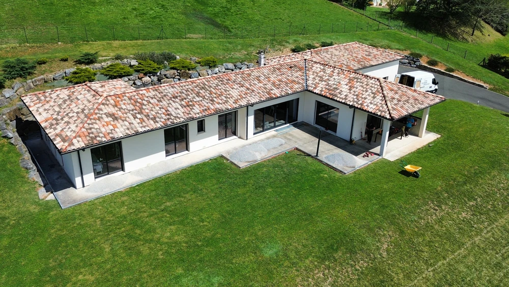 Terrasse extérieure moderne d'une maison contemporaine avec porte d'entrée anthracite à liserés métalliques